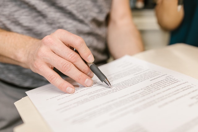 Person reviewing a legal document with a pen