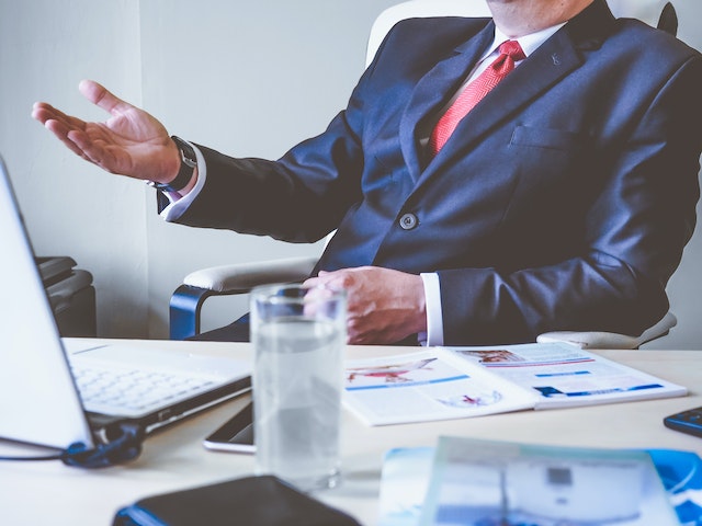 person in suit in front of a laptop