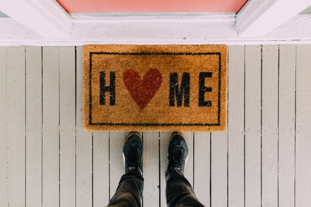 a doormat that says “home” with a heart instead of an ‘o’